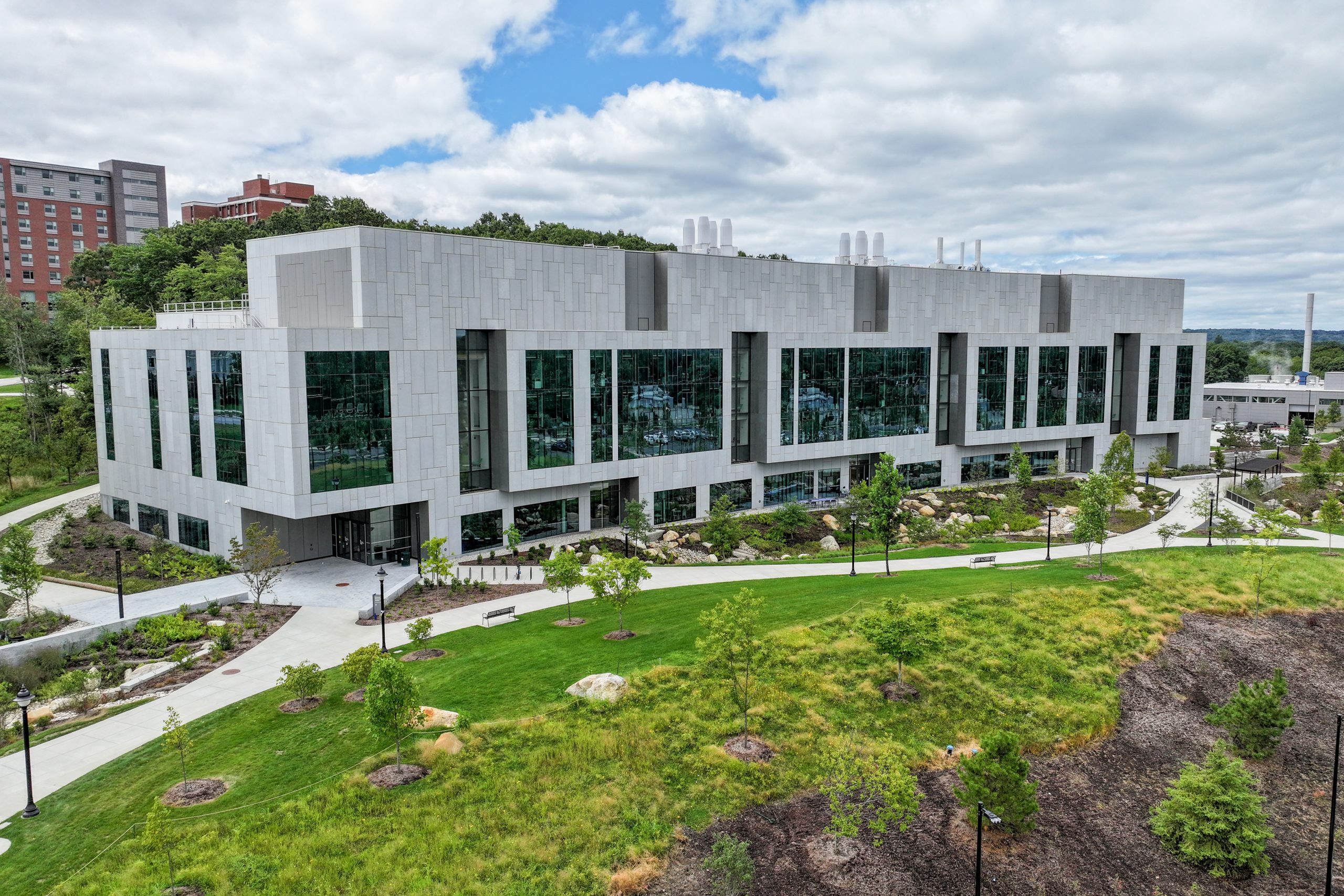 Exterior image of UConn's Science One building with cloudy skies and green grass.